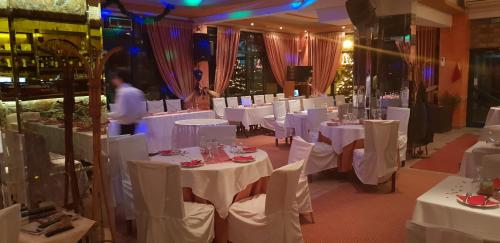 a dining room with white tables and white chairs at Apolis hotel in Mouzákion