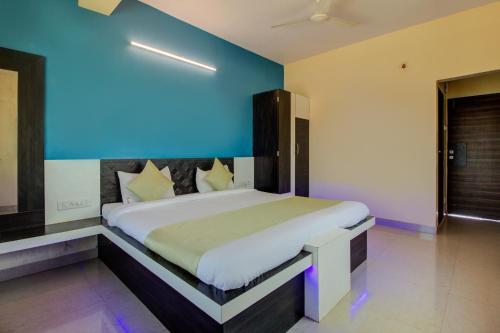 a bedroom with a large bed with a blue wall at Evergreen Holidays Mahabaleshwar in Mahabaleshwar