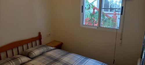 a bedroom with a bed and a window at Can Juvimar in El Poblenou del Delta