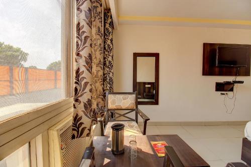 a living room with a table and a window at FabHotel PS Grand in Lucknow