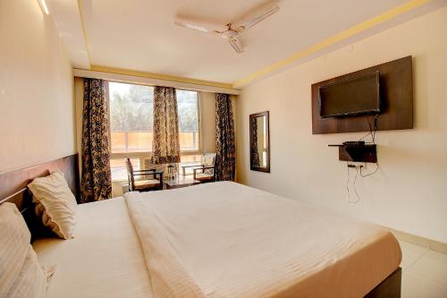 a bedroom with a large bed and a television at FabHotel PS Grand in Lucknow