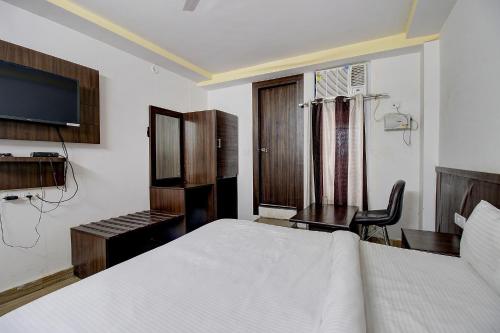 a bedroom with a bed and a desk and a television at FabHotel PS Grand in Lucknow