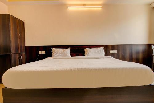 a large bed with white sheets and pillows at FabHotel PS Grand in Lucknow