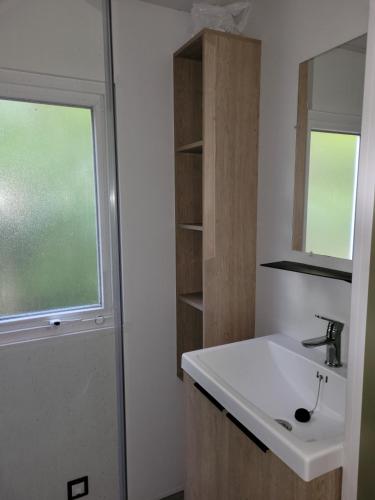 une salle de bain avec un lavabo et une fenêtre dans l'établissement Camping Les Chênes Verts, à Meschers-sur-Gironde