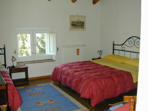 a bedroom with a red bed and a window at Case Zuccaro in Trecastagni