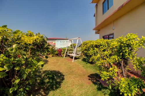 a garden next to a building with bushes at Evergreen Holidays Mahabaleshwar in Mahabaleshwar