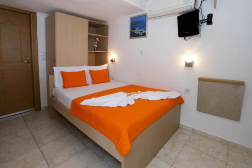 a bedroom with a bed with an orange blanket at Sunset Studios in Skala Marion