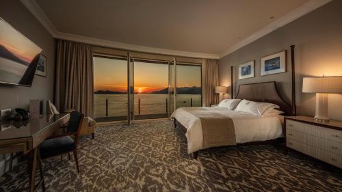 a bedroom with a bed and a desk and a window at Royal Blue Hotel in Dubrovnik