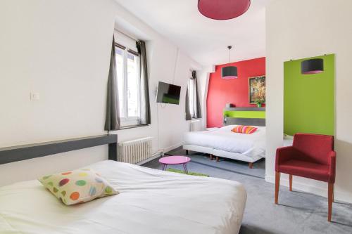 um quarto com uma cama e uma cadeira vermelha em Hôtel d'Angleterre em Versalhes