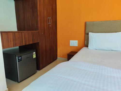 a bedroom with a bed and a cabinet with a white bed at JenJon Best Retreat Chalets at Sparsh Karjat Resort with optional SWIMMING POOL in Karjat