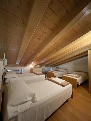 ヴェローナにあるRichi Rent 03のベッド4台が備わる木製の天井の客室です。