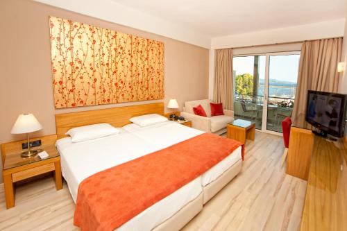 a hotel room with a bed and a television at Pharae Palace in Kalamata