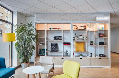 a room with shelves and chairs and a table at Aparthotel Adagio Access Paris Quai d'Ivry in Ivry-sur-Seine