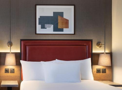 a bedroom with a bed, a lamp and a painting on the wall at Jurys Inn Birmingham in Birmingham