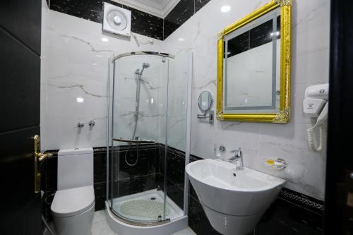 a bathroom with a sink and a glass shower at جراند سيزون للشقق المخدومة in Dammam
