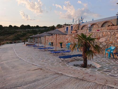 a row of blue lounge chairs and a building at Iris Villas in Spárton
