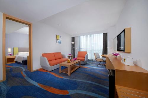 a hotel room with a bedroom and a living room at Holiday Inn Express Zhengzhou Zhengdong by IHG in Zhengzhou