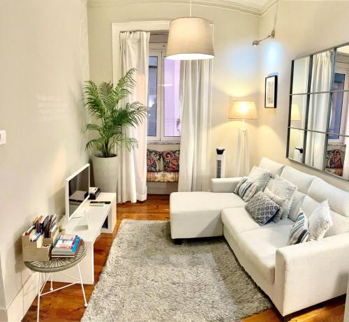 a living room with a white couch and a table at HOME4U in Lisbon