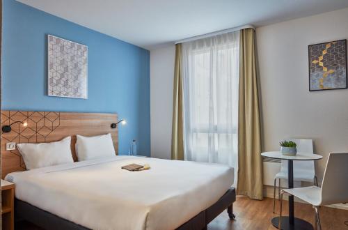 una camera d'albergo con un grande letto e una finestra di Aparthotel Adagio Access Paris Quai d'Ivry a Ivry-sur-Seine