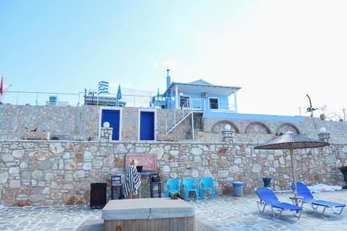 a patio with chairs and an umbrella and a building at Iris Villas in Spárton