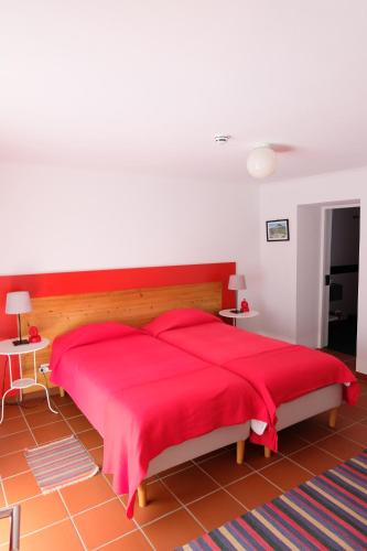 ein Schlafzimmer mit einem großen roten Bett mit roten Laken in der Unterkunft Casa da Malta in Livramento