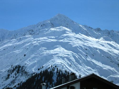 a snow covered mountain in front of a building at Haus Puit Mandarfen Pitztal in Sankt Leonhard im Pitztal