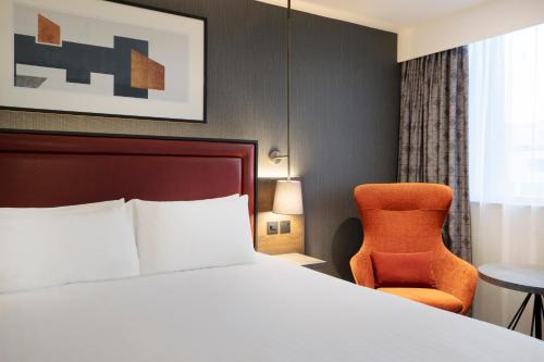 a hotel room with a bed and a chair at Leonardo Royal Hotel Birmingham - formerly Jurys Inn in Birmingham