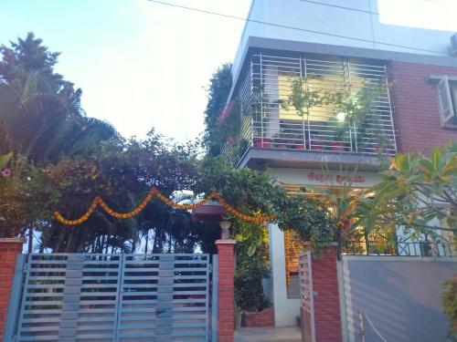 a house with a gate in front of a building at Mango Tree Homestay in Hampi