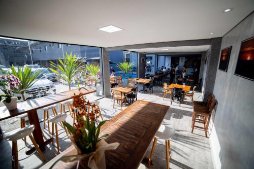 un restaurant avec une grande table et des chaises en bois dans l'établissement Pousada Cadiz - Piscina Climatizada, à Bertioga