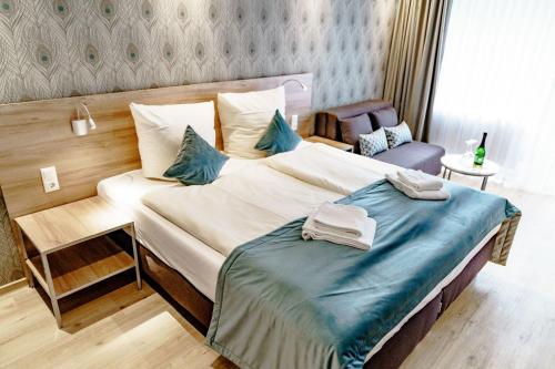 ハーネンクレー・ボックスヴィーゼにあるHaus am See Luxury HS 228 Bのベッドルーム1室(大型ベッド1台、青いシーツ付)