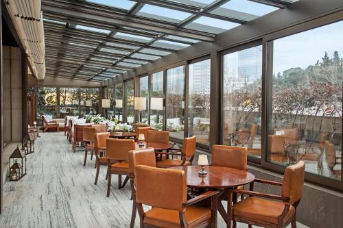 a restaurant with tables and chairs and large windows at Hyatt Centric Levent Istanbul in Istanbul