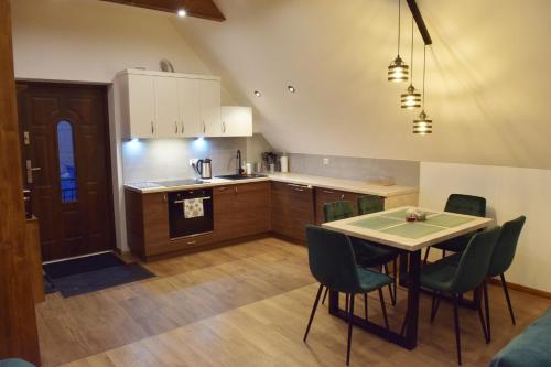 - une cuisine et une salle à manger avec une table et des chaises dans l'établissement Apartament CEKO, à Ostrowsko