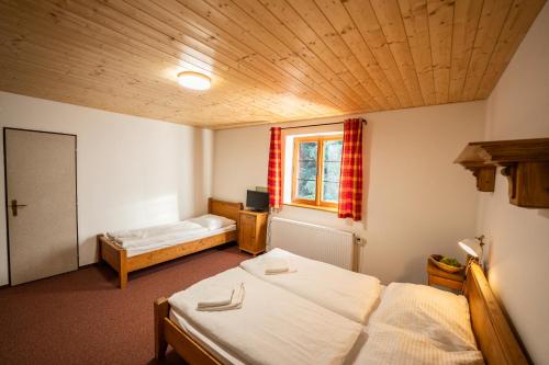 a room with two beds and a window at Penzion Panský dům in Kvilda