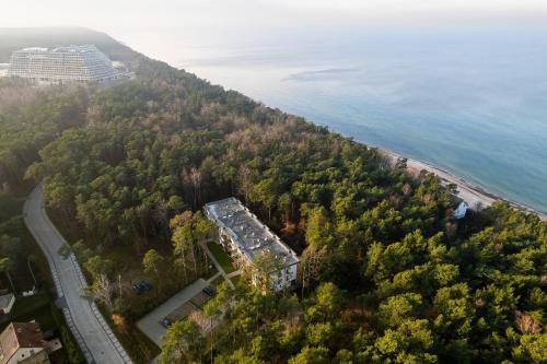 an aerial view of a house on a hill next to the ocean at Nadmorskie Studio z Balkonem - Grunwaldzka Pobierowo by Renters in Pobierowo