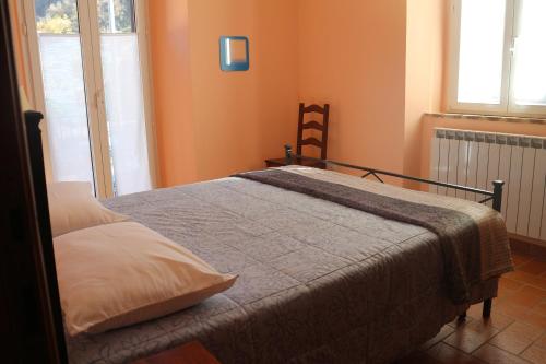 Cama en habitación con paredes de color naranja en Casa vacanze con balcone Valleremita - Analogic tour, en Fabriano
