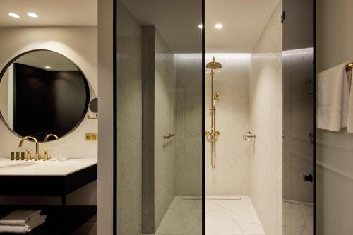 a bathroom with a shower and a sink and a mirror at Van der Valk Hotel Beveren in Beveren