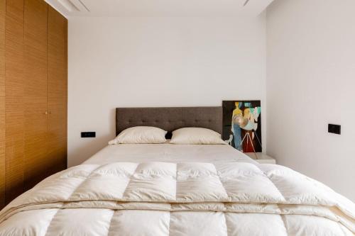 - une chambre avec un grand lit et des draps blancs dans l'établissement Lovely "Findy 101" with free parking, à Rabat