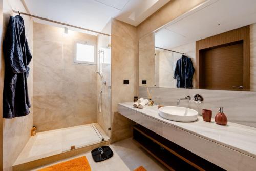 La salle de bains est pourvue d'un lavabo, d'une douche et d'un miroir. dans l'établissement Lovely "Findy 101" with free parking, à Rabat