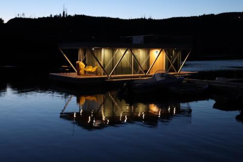 una piccola barca seduta sull'acqua di notte di Floating Álvaro ad Alvaro