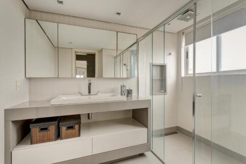 a bathroom with a sink and a mirror at Triplex com jacuzzi na melhor vista de Floripa! in Florianópolis