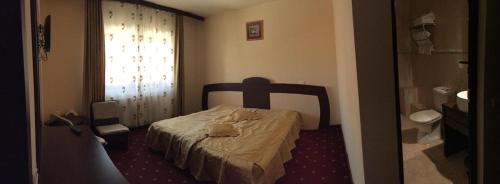 a small bedroom with a bed and a bathroom at Casa Amurg in Sinaia