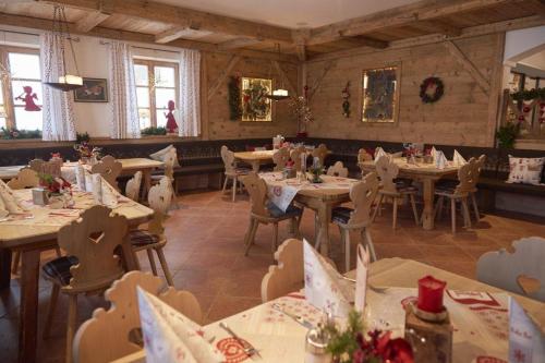 a restaurant with tables and chairs in a room at Berghotel Birkenhof GmbH in Reit im Winkl