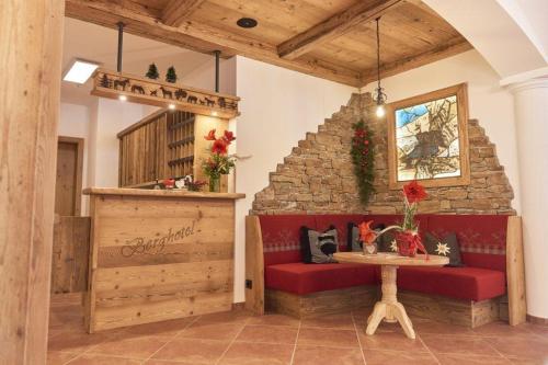 a room with a red bench and a stone wall at Berghotel Birkenhof GmbH in Reit im Winkl