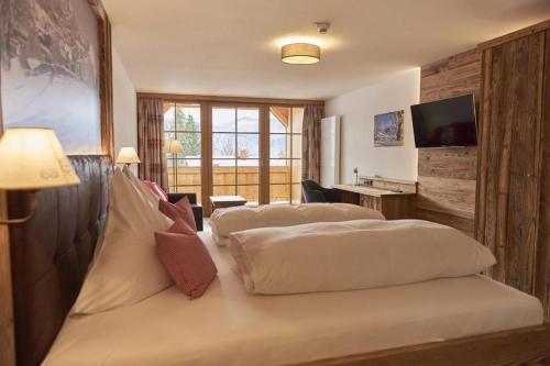 a hotel room with two beds and a television at Berghotel Birkenhof GmbH in Reit im Winkl