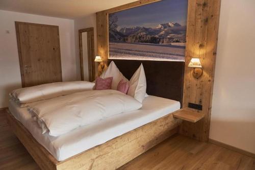a bedroom with a large white bed in a room at Berghotel Birkenhof GmbH in Reit im Winkl