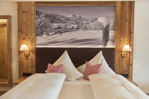 a bedroom with a bed with a picture on the wall at Berghotel Birkenhof GmbH in Reit im Winkl