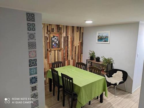 a dining room with a green table and chairs at Casa 5-6 Personas Puerto Natales in Puerto Natales