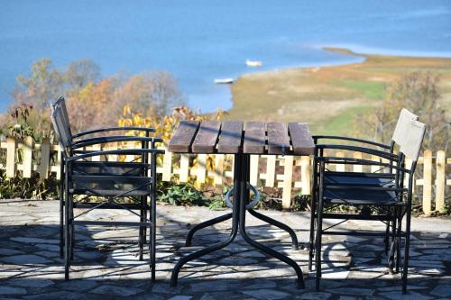two chairs and a wooden table and two chairs at Ξενώνας Παρατηρητήριο Υπερώον in Ágios Athanásios