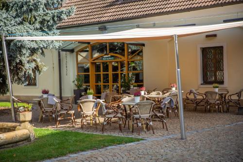 a patio with tables and chairs under an umbrella at Hotel Baroko in Prague