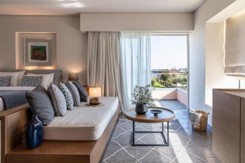 a bedroom with a bed and a couch and a window at Eden Roc Resort - All Inclusive in Kallithea Rhodes